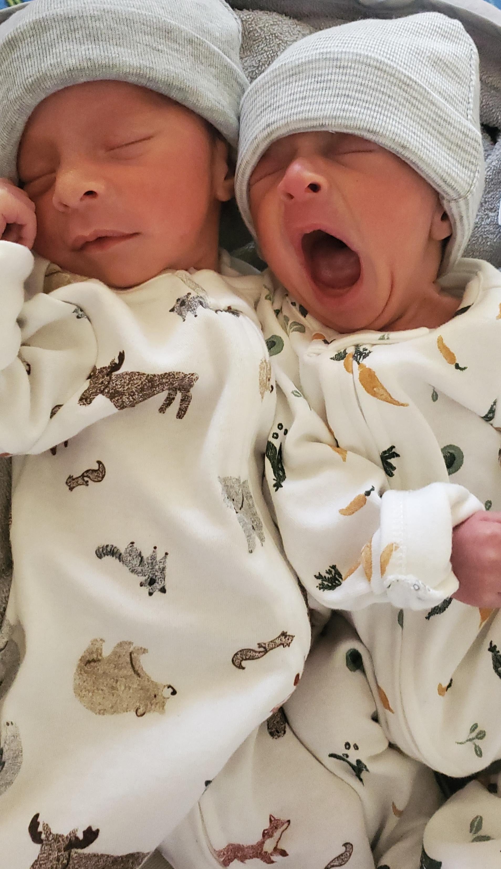 Twin boys sleeping and one boy yawning